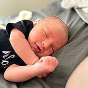 Michael joined the competition — help win amazing prizes! baby, newborn, sleeping, infant, black_clothing, bed, blanket, soft, peaceful, portrait, closeup, skin, hand, face, rest, young_child, cute, cozy, indoors, relaxation