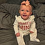 baby, child, infant, smiling, headband, bow, polka_dot, onesie, bed, blanket, gray, happy, sitting, cute, indoors, portrait, face, blue_eyes, pink, clothing