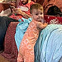 beard, blanket, blue_blanket, bottle, carpet, child, couch, dr_pepper_box, furniture, hat, indoor, man, orange_clothing, pattern, phone, red_shirt, romper, stone_wall, tattoo, toddler