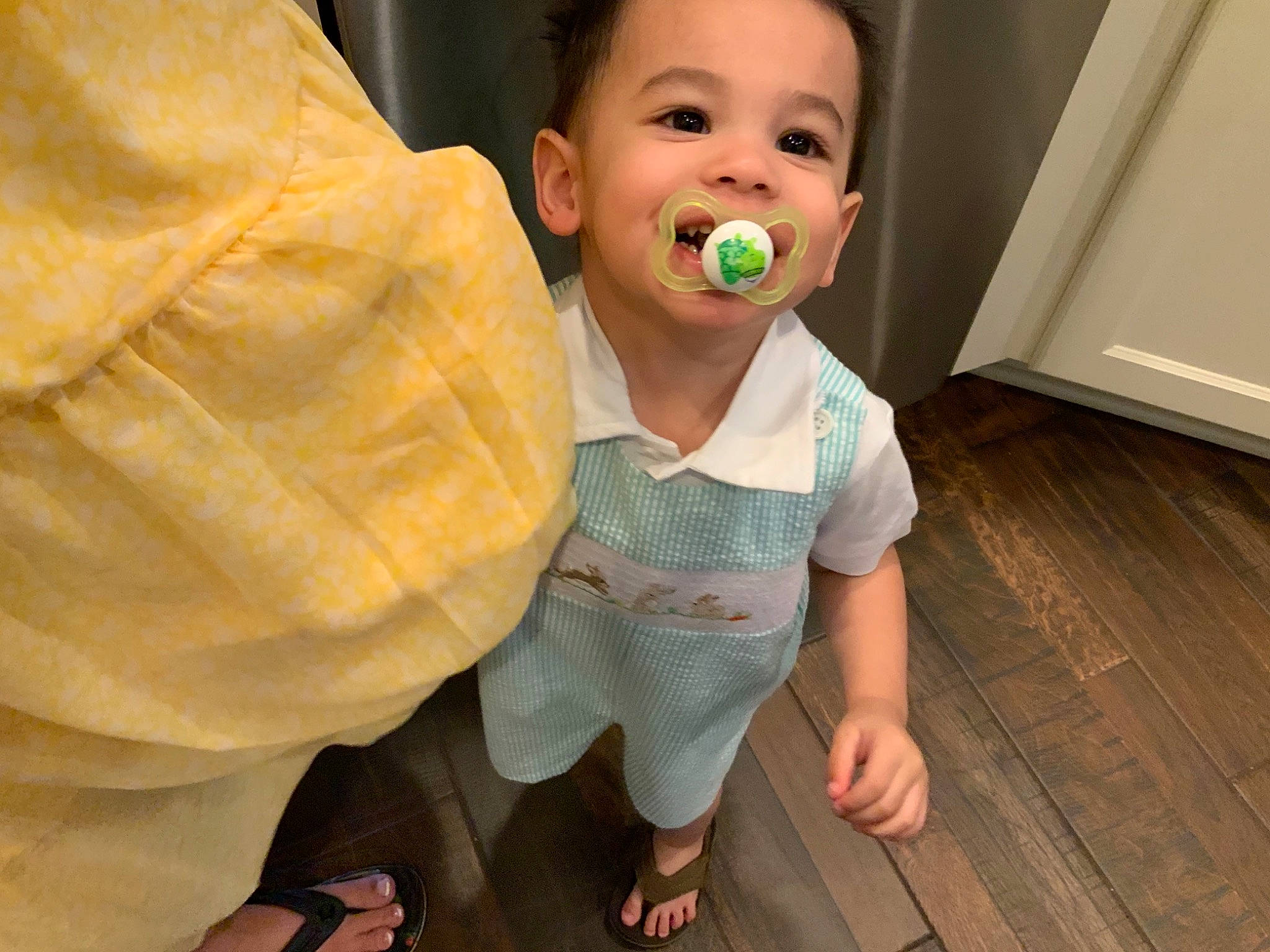 Samuel is registered to the contest to win money with this photo: baby, baby_toddler_clothing, barefoot, cheek, child, finger, flooring, foot, fun, gesture, happy, hardwood, joy, mouth, nose, person, sandal, skin, sleeve, thumb