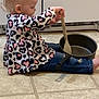 Olivia is registered to the contest to win money with this photo: toddler, child, kitchen, floor, pot, wooden_spoon, jeans, long_sleeve_shirt, patterned_clothing, playing, cooking, indoor, tile_floor, blond_hair, side_view, sitting, young_child, curious, pretend_play, casual_clothing