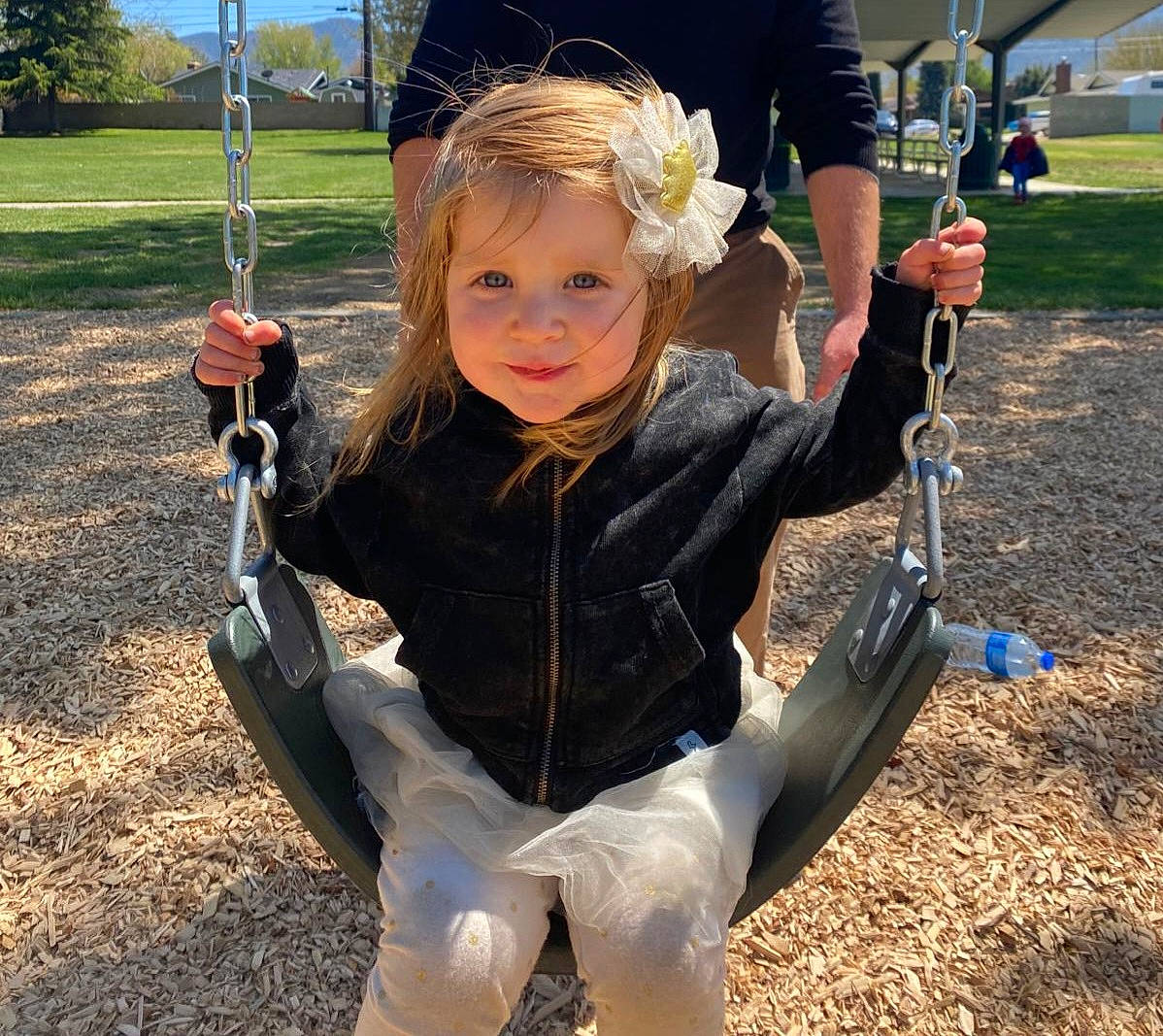 Adelyn joined the competition — help win amazing prizes! baby, child, city, eye, fun, grass, happy, leisure, outdoor_play_equipment, people_in_nature, person, plant, play, playground, recreation, sitting, smile, swing, t_shirt, toddler