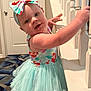 Gwendalyn is registered to the contest to win money with this photo: baby, girl, tutu_dress, headband, bow, indoor, staircase, banister, curious, child, clothing, carpet, door, person, smiling, face, hand, blue, white, young