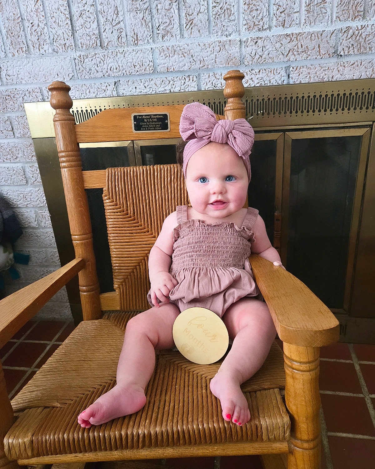 Evelyn joined the competition — help win amazing prizes! baby, child, infant, pink_bow, headband, wooden_chair, smiling, blue_eyes, four_months_sign, cozy, indoor, brick_wall, fireplace, cute, sitting, plush, wood, floor_tiles, happy, portrait