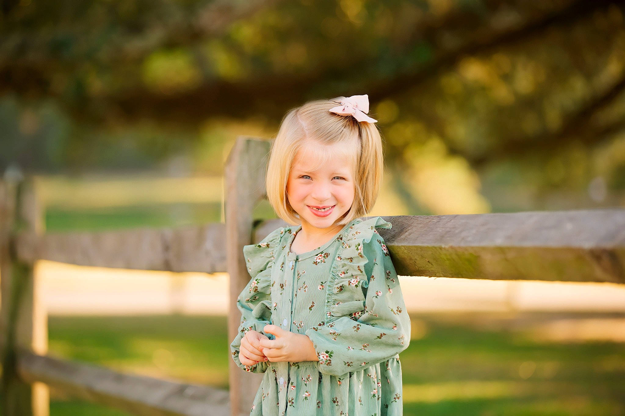 Shea is registered to the contest to win money with this photo: blond, child, fence, flash_photography, forest, fun, grass, grassland, happy, joy, landscape, leaf, leisure, people_in_nature, person, recreation, sitting, smile, spring, toddler