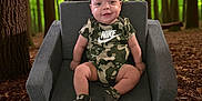 Dante joined the competition — help win amazing prizes! baby, child, smile, face, armchair, clothing, nike, camouflage, forest, trees, greenery, leaf_litter, outdoor, nature, sitting, happy, infant, footwear, cute, portrait