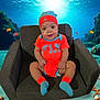 baby, child, armchair, orange_clothing, blue_clothing, hat, socks, smiling, indoor, underwater_background, fish, coral, sea_life, digital_background, cute, portrait, happy, infant, seated, playful