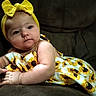 Willow joined the competition — help win amazing prizes! baby, child, infant, yellow_headband, bow, sunflower_dress, couch, dark_background, portrait, cute, soft_lighting, relaxed, indoors, skin, face, smiling, hand, sitting, baby_clothes, young_child