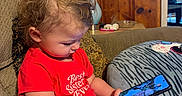 Willow joined the competition — help win amazing prizes! best_sister_ever, cat_face, child, couch, curly_hair, cute, diaper, focused, furniture, glasses, indoors, interior, lamp, person, pillow, red_shirt, sitting, smartphone, toddler, wood_paneling