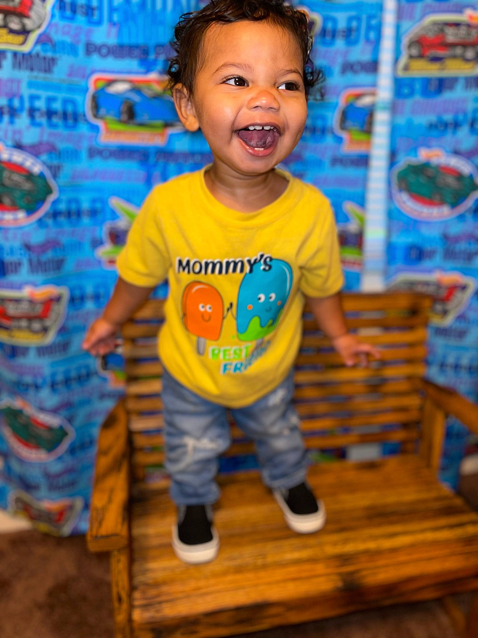 Kyson is registered to the contest to win money with this photo: baby_toddler_clothing, blue, child, electric_blue, flooring, fun, happy, hardwood, leisure, logo, pattern, person, play, shorts, sleeve, smile, standing, t_shirt, toddler, wood