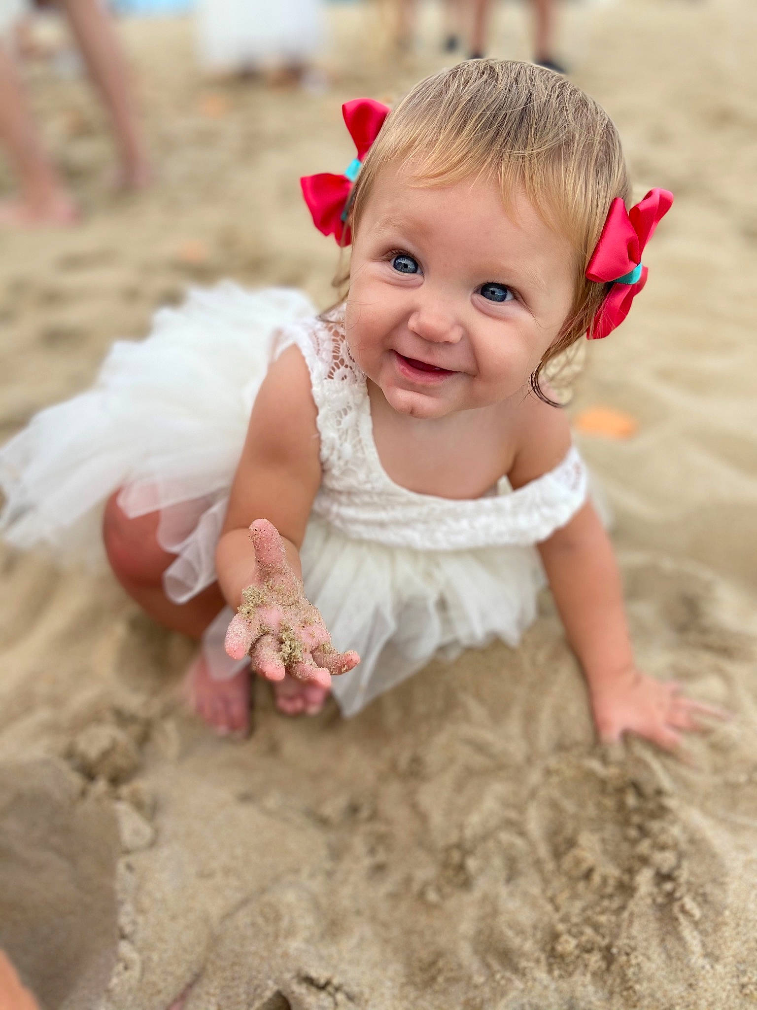Kaelynn is registered to the contest to win money with this photo: baby, baby_toddler_clothing, child, dress, eye, facial_expression, flower, fun, grass, happy, joy, people_in_nature, person, petal, pink, sand, sitting, skin, sleeve, smile