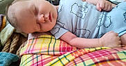 Ryan joined the competition — help win amazing prizes! baby, bear_print, blanket, child, clothing, comfort, cozy, cute, face, hand, head, home, indoor, infant, onesie, peaceful, plaid, resting, sleeping, soft