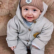 Amine participe au concours pour gagner de l'argent avec cette photo : baby, child, smiling, hat, pom_pom, knitwear, sitting, couch, buttoned_sweater, shoes, cozy, indoors, cute, happy, portrait, person, face, warm_clothing, infant, button