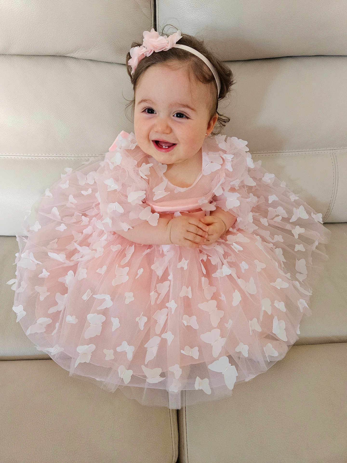Giulia participe au concours pour gagner de l'argent avec cette photo : baby, child, dress, pink, butterflies, headband, smiling, happy, sitting, couch, leather, cute, toddler, portrait, indoor, hands, furniture, fashion, girl, person