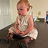 Kinsley is registered to the contest to win money with this photo: baby, boots, casual, child, countertop, curly_hair, cute, dress, floor, focused, home, indoor, kitchen, person, playful, sitting, small, toddler, toy, young_child