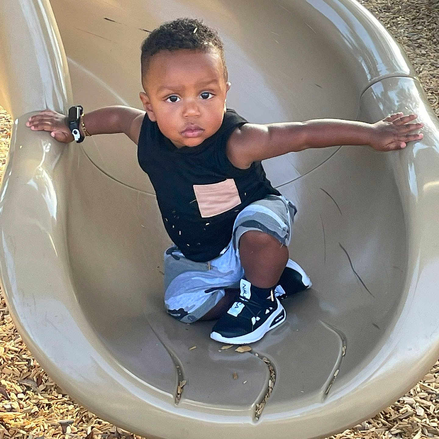Justin joined the competition — help win amazing prizes! active, arms_outstretched, black_shirt, black_shoes, casual_clothing, child, daylight, determined_expression, fun, outdoor, park, person, play, playground, recreation, shorts, slide, toddler, wood_chips, young_child