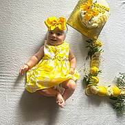 Mellina participe au concours pour gagner de l'argent avec cette photo : 4_months, baby, blanket, bow, cake, celebration, child, cute, decorations, flowers, happy, headband, indoors, infant, laying_down, lemons, milestone, portrait, smiling, yellow_dress