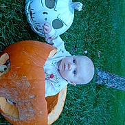 Maxwell joined the competition — help win amazing prizes! baby, blue_eyes, pumpkin, carved_pumpkin, skull_mask, grass, tree_trunk, outdoor, child, fall, halloween, costume, cute, sitting, nature, seasonal, holiday, playful, face, person