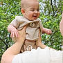 Oliver is registered to the contest to win money with this photo: adult, baby, child, cute, daylight, face, family, greenery, hands, happy, holding, joy, nature, outdoor, person, playful, portrait, smiling, sweater, trees