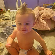 Brandon joined the competition — help win amazing prizes! baby, infant, child, sitting, smiling, portrait, face, topknot, diaper, bedroom, bed, blanket, bedding, indoor, home, purple_wall, furniture, cozy, happy, photography