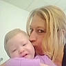Serenity is registered to the contest to win money with this photo: baby, infant, adult, woman, cuddling, kiss, portrait, close_up, face, blonde_hair, sleepy, eyes_closed, purple_clothing, indoors, soft_lighting, family, affection, hug, baby_clothing, selfie