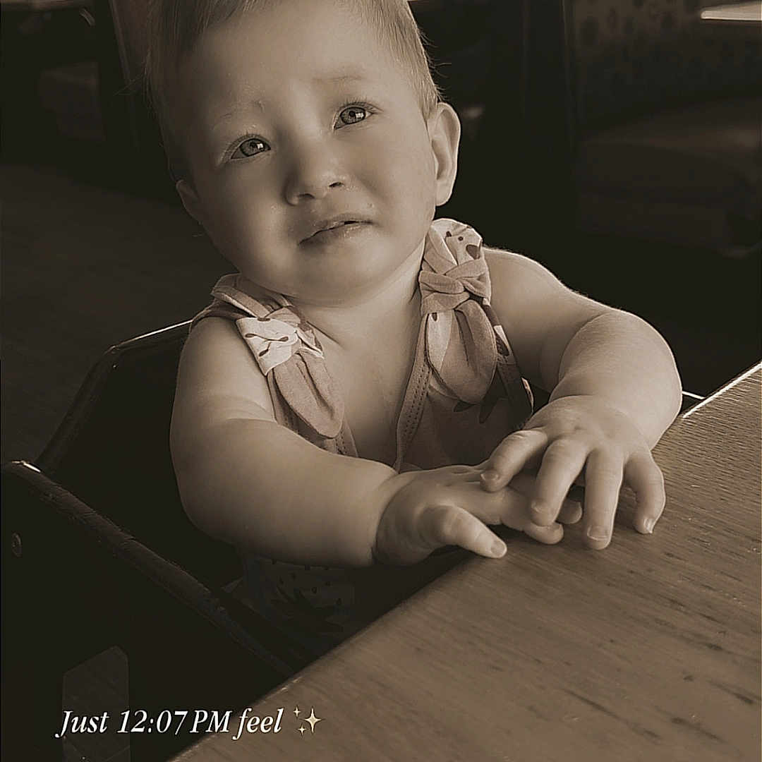Serenity joined the competition — help win amazing prizes! baby, child, toddler, portrait, restaurant, dining, table, high_chair, sitting, reaching, hands, curious, neutral_expression, sepia, vintage, indoor, window, booth, background_people, text_overlay