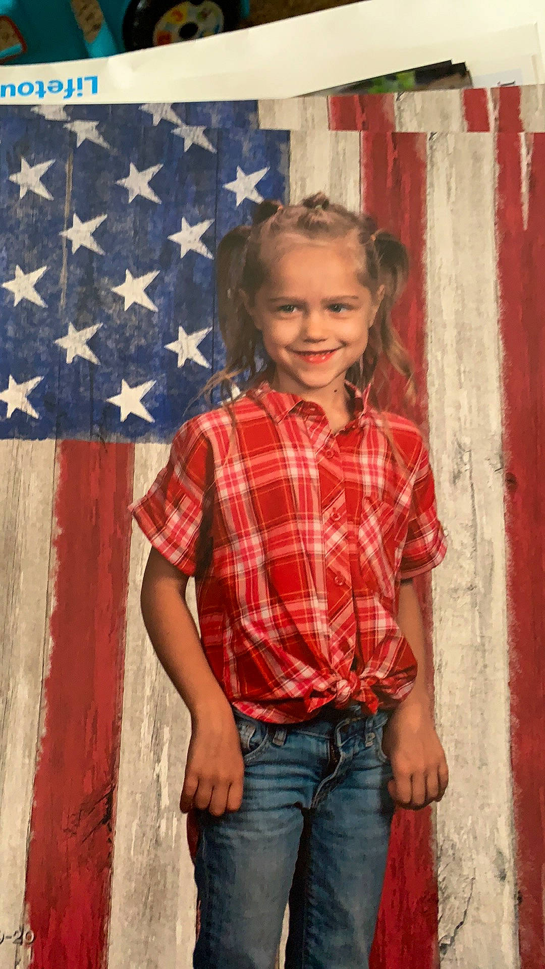 Jordynn is registered to the contest to win money with this photo: clothing, denim, door, dress_shirt, fashion, flag_of_the_united_states, fun, happy, human_body, jeans, joy, organ, person, plaid, red, sleeve, smile, standing, tartan, textile