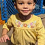 Brooklynn is registered to the contest to win money with this photo: child, toddler, smiling, yellow_clothing, hair_accessory, indoor, face, person, happy, cute, portrait, young_child, colorful, play_area, plastic_fence, background, standing, long_sleeve, pants, close_up
