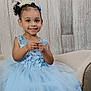 Brooklynn is registered to the contest to win money with this photo: child, smiling, girl, blue_dress, lace, chair, curly_hair, hair_accessories, indoor, portrait, cute, happy, young, seated, person, fashion, tulle, background, wooden_wall, studio