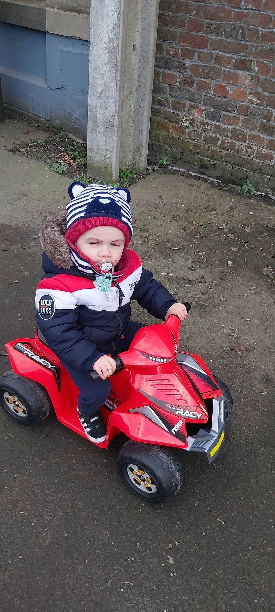 Thiago participe au concours pour gagner de l'argent avec cette photo : car, headwear, person, riding_toy, toddler, vehicle