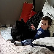 Nate is registered to the contest to win money with this photo: toddler, child, dog, bed, pillow, blanket, indoor, furniture, pet, animal, resting, comfort, clothing, striped_pants, dark_hair, home, relaxation, cute, cozy, portrait
