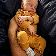 Oppie joined the competition — help win amazing prizes! baby, sleeping, infant, yellow_outfit, socks, arm, hand, blanket, bed, rest, peaceful, cozy, person, indoor, soft_lighting, portrait, newborn, comfort, cuddle, relaxation