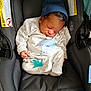 baby, newborn, sleeping, car_seat, pacifier, hat, clothing, infant, cute, child, resting, black, grey, blue, dinosaur_print, indoors, seatbelt, soft, peaceful, small