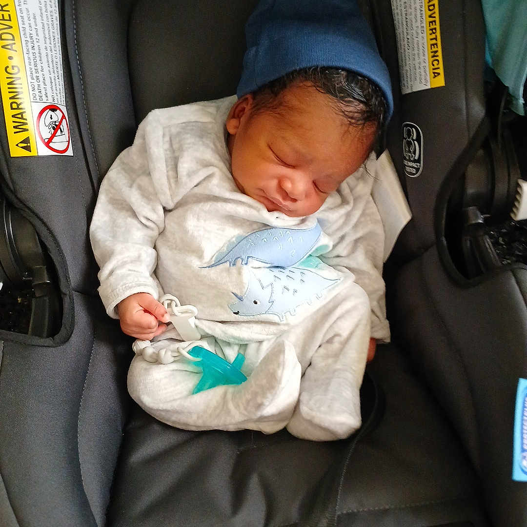 Tyon joined the competition — help win amazing prizes! baby, black, blue, car_seat, child, clothing, cute, dinosaur_print, grey, hat, indoors, infant, newborn, pacifier, peaceful, resting, seatbelt, sleeping, small, soft