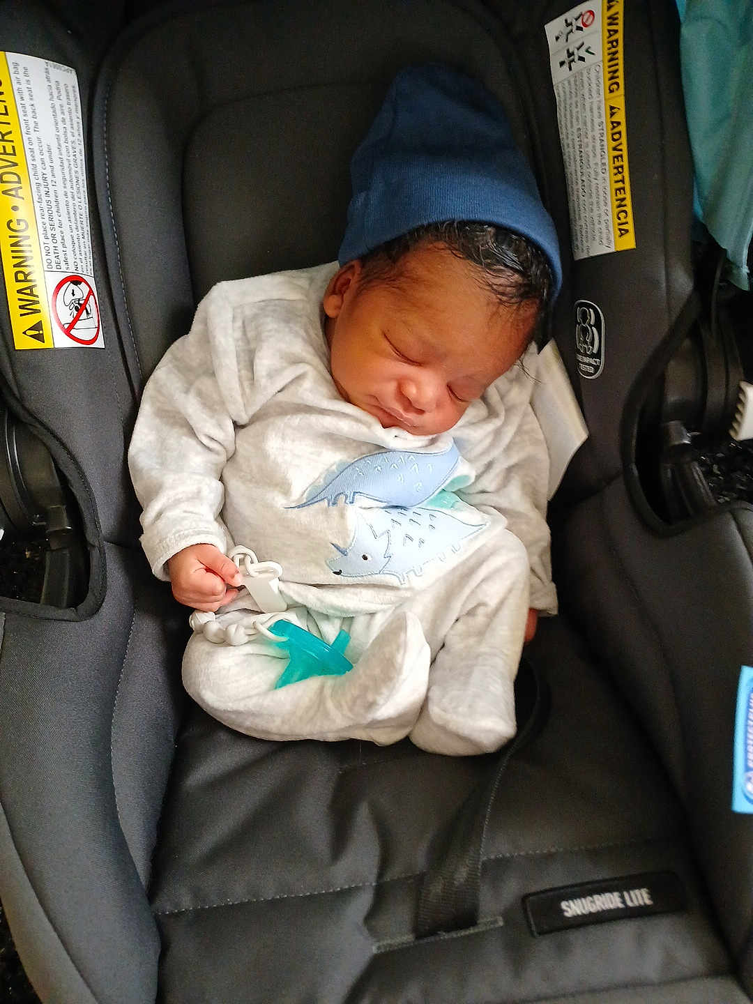 Tyon joined the competition — help win amazing prizes! baby, newborn, sleeping, car_seat, pacifier, hat, clothing, infant, cute, child, resting, black, grey, blue, dinosaur_print, indoors, seatbelt, soft, peaceful, small