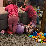 Vaeh is registered to the contest to win money with this photo: baby, carpet, casual, child, cushion, floor, happy, indoor, mirror, ottoman, person, pink_clothing, playtime, plush_toy, reflection, room, smile, toddler, toy, wooden_furniture