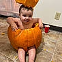 baby, child, cute, expression, face, feet, floor, halloween, hand, holiday, indoor, legs, messy, orange, person, playful, pumpkin, red_cup, sitting, tile_floor