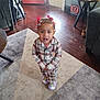 Rumanni is registered to the contest to win money with this photo: child, indoor, pajamas, plaid, carpet, wooden_floor, slippers, rainbow, red_bows, hair_accessories, furniture, plant, table, door, home_interior, person, standing, floor, decor, blurred_face