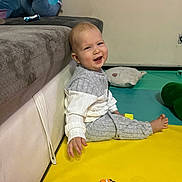 Aaron participe au concours pour gagner de l'argent avec cette photo : baby, child, smile, happy, indoor, playmat, toy, pacifier, couch, plush_toy, clothing, floor, sitting, face, person, head, hand, foot, room, infant