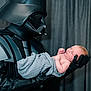 baby, darth_vader, costume, helmet, gloves, armor, blanket, newborn, infant, person, portrait, indoor, curtain, black_clothing, child, holding, side_view, face, caring, fantasy