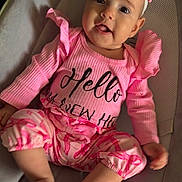 Arlanys is registered to the contest to win money with this photo: baby, child, infant, girl, pink_clothing, headband, smiling, sitting, baby_seat, cushion, cute, happy, indoors, portrait, person, young_child, apparel, fashion, soft_lighting, comfortable