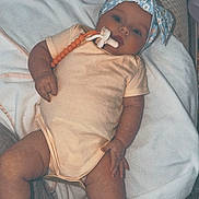 Nightlynn is registered to the contest to win money with this photo: baby, infant, child, portrait, lying_down, blanket, bow_headband, pacifier, onesie, cushion, chair, indoor, cozy, relaxed, awake, face, hands, feet, photography, home