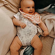 Nightlynn joined the competition — help win amazing prizes! baby, barefoot, bed, bib, blanket, child, closeup, cozy, dog_paw, family, floral_outfit, happy, home, indoors, infant, lying_down, onesie, pillow, portrait, smiling
