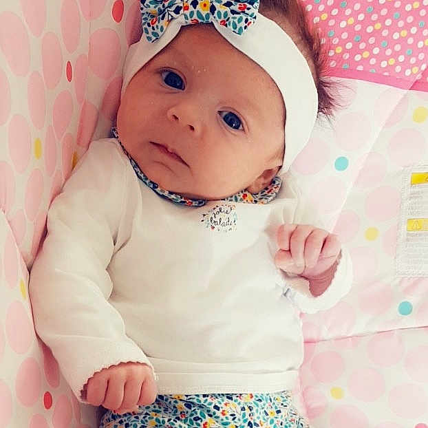 Eléana participe au concours pour gagner de l'argent avec cette photo : cheek, child, design, girl, hair_accessory, headwear, infant, material, nightwear, nose, pattern, peach, person, pink, product, skin, sleeve, smile, textile, toddler