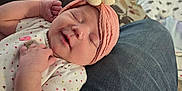 Ruby is registered to the contest to win money with this photo: baby, sleeping, headband, flower, pink, clothing, denim, lap, person, living_room, carpet, rabbit, pet, furniture, couch, blanket, cozy, indoor, cute, relaxing
