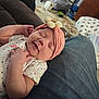 baby, sleeping, headband, flower, pink, clothing, denim, lap, person, living_room, carpet, rabbit, pet, furniture, couch, blanket, cozy, indoor, cute, relaxing