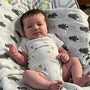 Ruby is registered to the contest to win money with this photo: baby, infant, onesie, blanket, pattern, cushion, seat, clothing, face, skin, hand, foot, indoor, cute, child, newborn, expression, head, person, resting