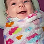 Ruby is registered to the contest to win money with this photo: baby, blanket, cheeks, close_up, eyes, face, floral_pattern, hair, happy, infant, laugh, lying_down, nursery, pillow, plush, portrait, skin, smile, soft_texture, swaddle