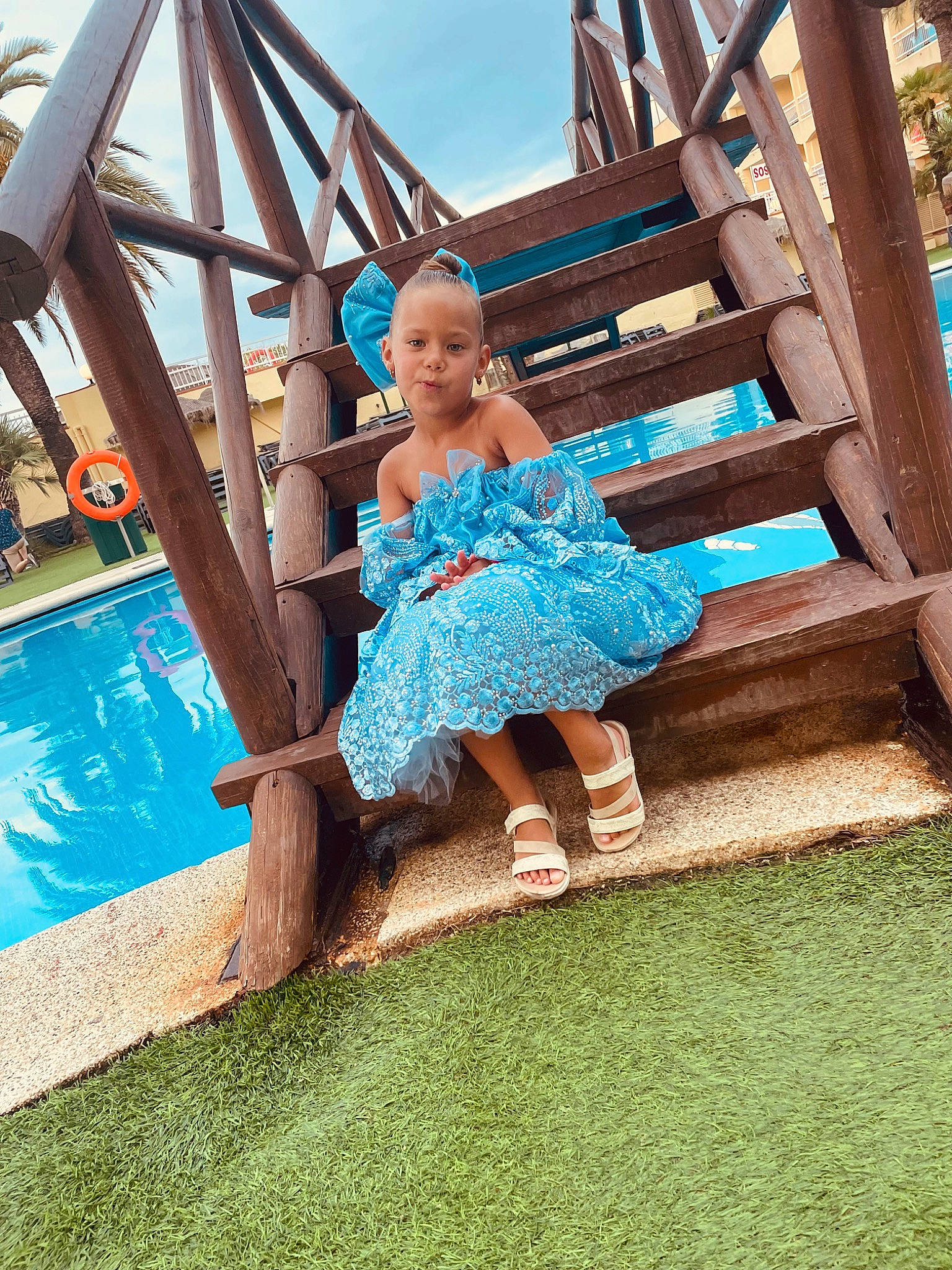 Lyhanna participe au concours pour gagner de l'argent avec cette photo : aqua, azure, barefoot, child, dress, electric_blue, fun, grass, happy, human_leg, leisure, outdoor_furniture, people_in_nature, person, play, recreation, sandal, sitting, sky, swimming_pool