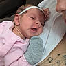 Eliyah'Ann is registered to the contest to win money with this photo: baby, infant, sleeping, headband, flower, pink_clothing, mitten, blanket, adult, parent, cuddling, portrait, indoors, cozy, face, closed_eyes, peaceful, family, newborn, photography